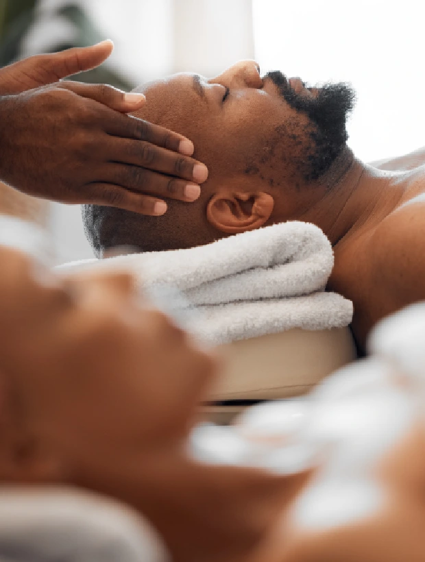 A man getting his face washed by two hands.