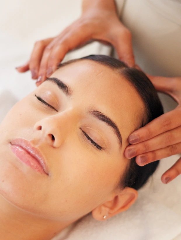 A woman getting her face washed with hands.